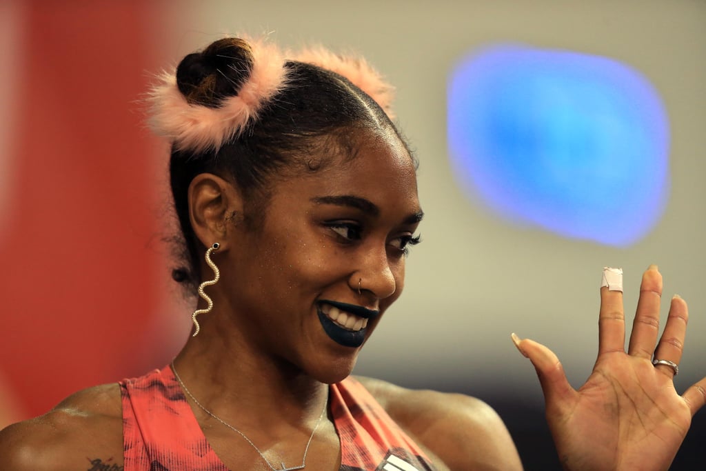 Wearing space buns with pink fuzzy scrunchies, dark lipstick, and snake earrings at the IAAF World Indoor Tour in 2018.