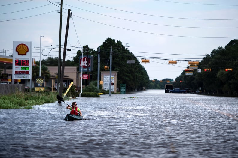 A woman kayaks through a flooded street in Houston, TX.