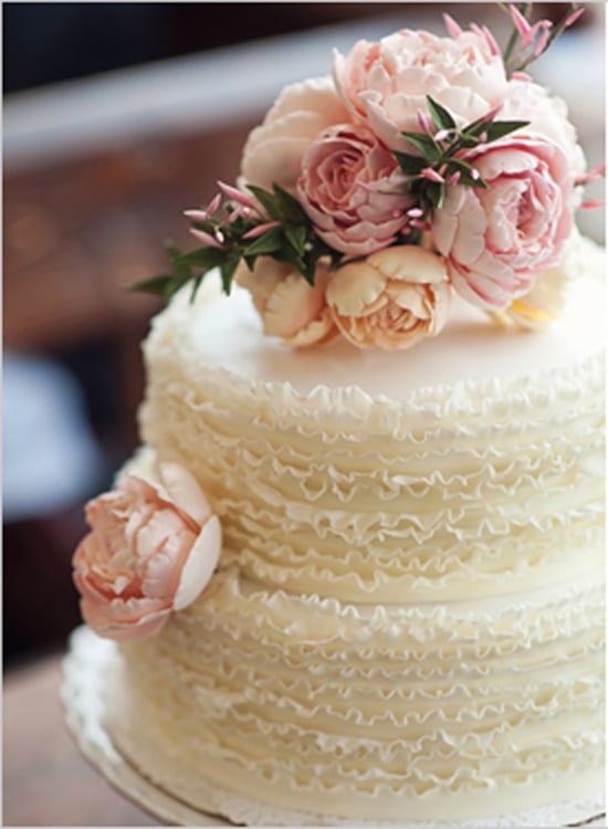 There's something so sweet about this simple but beautiful cake — the ruffles and flowers make the perfect classic combo. 
Photo by Oh, Darling! via Wedding Chicks