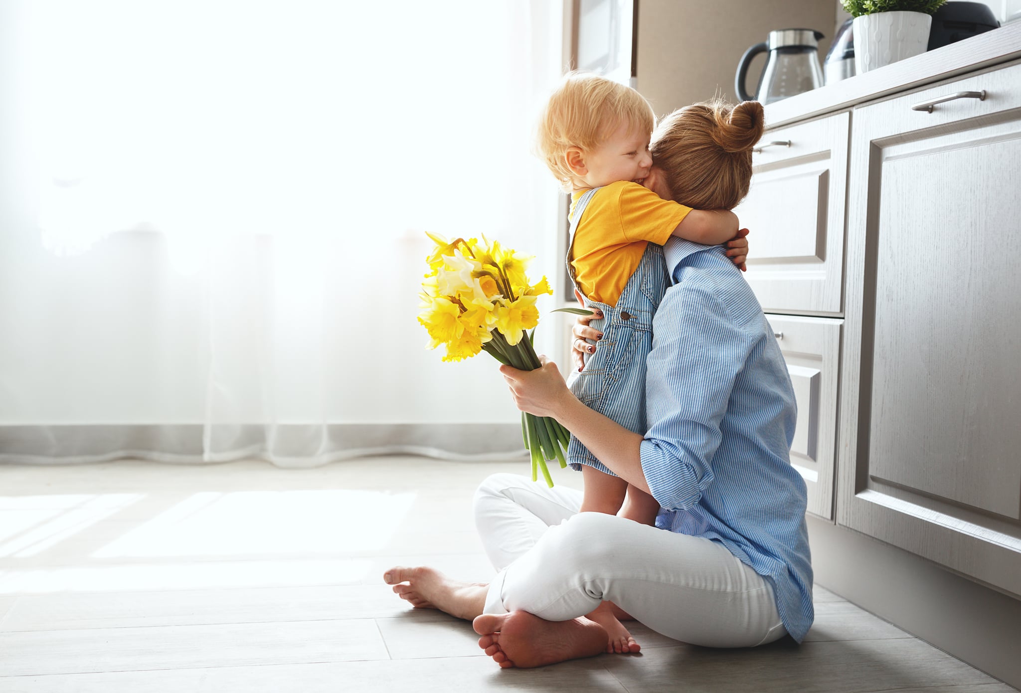 happy mother's day! baby son congratulates mother on holiday and gives flowers