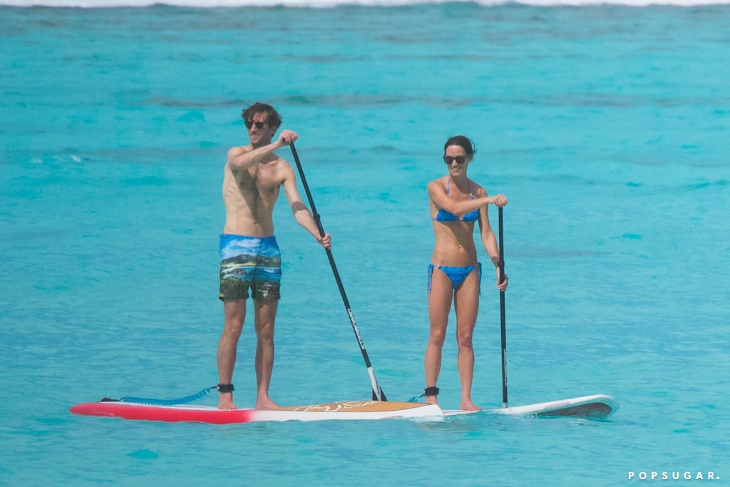 After an idyllic, fairy-tale wedding in the UK on May 20, Pippa Middleton and her new husband, James Matthews, jetted off to French Polynesia for an idyllic, fairy-tale honeymoon. Over the weekend, the couple was spotted on the beach in Tetiaroa, a chain of islands in French Polynesia that is basically paradise; they walked along the sand with books in hand, and Pippa showed off her toned physique in a bright blue bikini as they did some stand-up paddleboarding together. Pippa also slipped into a classic bridal white two-piece as she and James held hands during a sunny stroll. On Wednesday, the pair continued their adventures in Australia by boarding a seaplane in Sydney Harbor. They then finished off the week by going for a jog with a personal trainer in Sydney. 

    Related:

            
            
                                    
                            

            Blast From the Past! See Kate and Pippa Middleton&apos;s Sweetest Wedding Moments, Side by Side
        
    
Pippa and James tied the knot on May 20 at St. Mark's Englefield in Berkshire, before treating guests to an evening reception at Carole and Michael Middleton's home in Bucklebury. The guest list included Pippa's older sister, Kate, who arrived with Prince William and tended to a group of young flower girls and page boys that included her own two kids, Princess Charlotte and Prince George. While we didn't get a glimpse of Prince Harry and his girlfriend, Meghan Markle, at the event, the couple reportedly met up before the reception — but due to Pippa's strict seating plan, they didn't get to sit together.