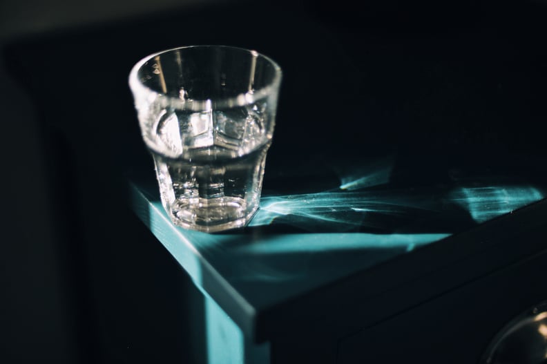Glass of water in strong sunlight on bedside table