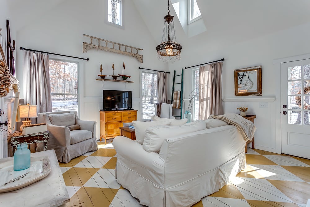 Slipcover seating, a chandelier, and drapes make the space feel rustic and cozy yet elegant.