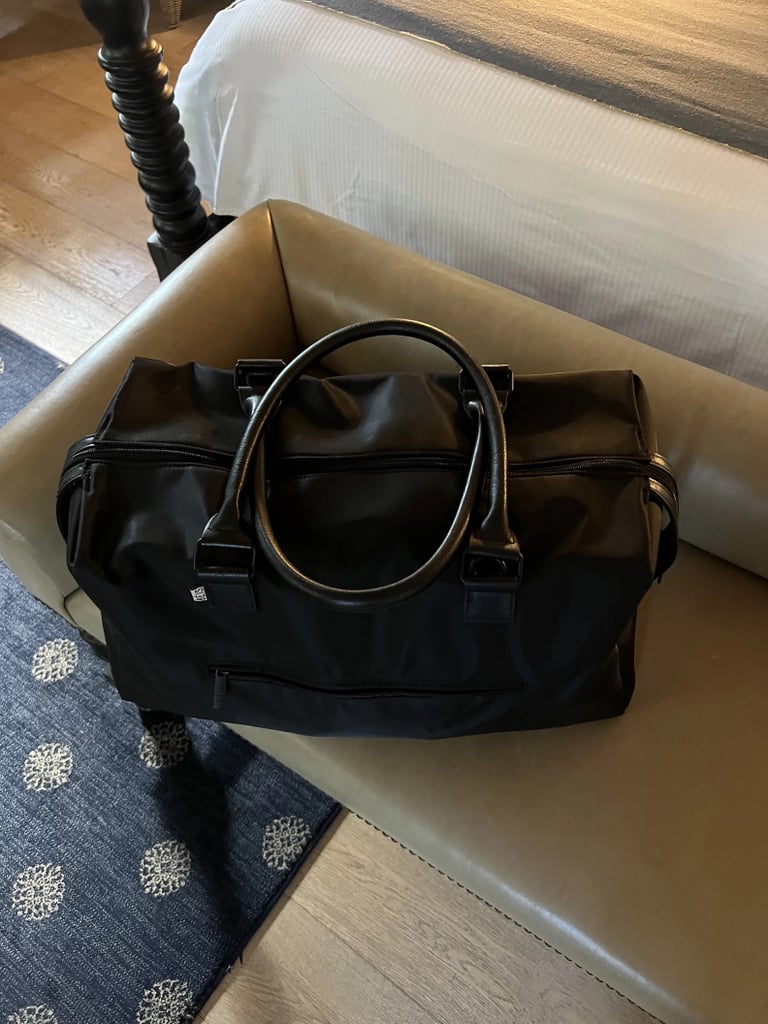 Béis The Commuter Duffle ($119, originally $158)
Although we're huge fans of the bestselling Béis Mini Weekender Bag, its Commuter Duffle is a worthy competitor. It has a capacity of 24.2 liters, and comes in a classic black color. The bag is designed for the busybody who's constantly on the go; it has two slip pockets on either side for water bottles or umbrellas and a zipper pocket in the front. Plus, the interior has the perfect blend of spaciousness and organization. Not only is there a padded laptop pocket, but also four elastic pockets (two of which are mesh), as well as a zipper pocket. 
This bag maintains is sleek silhouette and crisp look with five metal feet that let it stand on its own. It's made from a water resistant nylon, but it has vegan leather top handles and a padded leather adjustable strap.

Pros: Stylish design and comes with a key leash.
Cons: Some would prefer a side-to-side strap.
Material: Nylon, PU trim, and polyester.
Dimensions: 12" height x 21.5" width x 9" depth
Colorways: 1
Who it's best for: The weekend traveler and everyday commuter.
Editor Quote: "I love how sleek the bag looks and the fact that its incredibly lightweight. I took it as my plus-one on a recent trip to Sedona and managed to fit everything and more into the accessory — including seven outfits, two pairs of shoes, my toiletry bag, portable steamer, and more." — Kyley Warren, former assistant shopping editor

Read more about The Commuter Duffle in our review of the Béis Commuter collection.