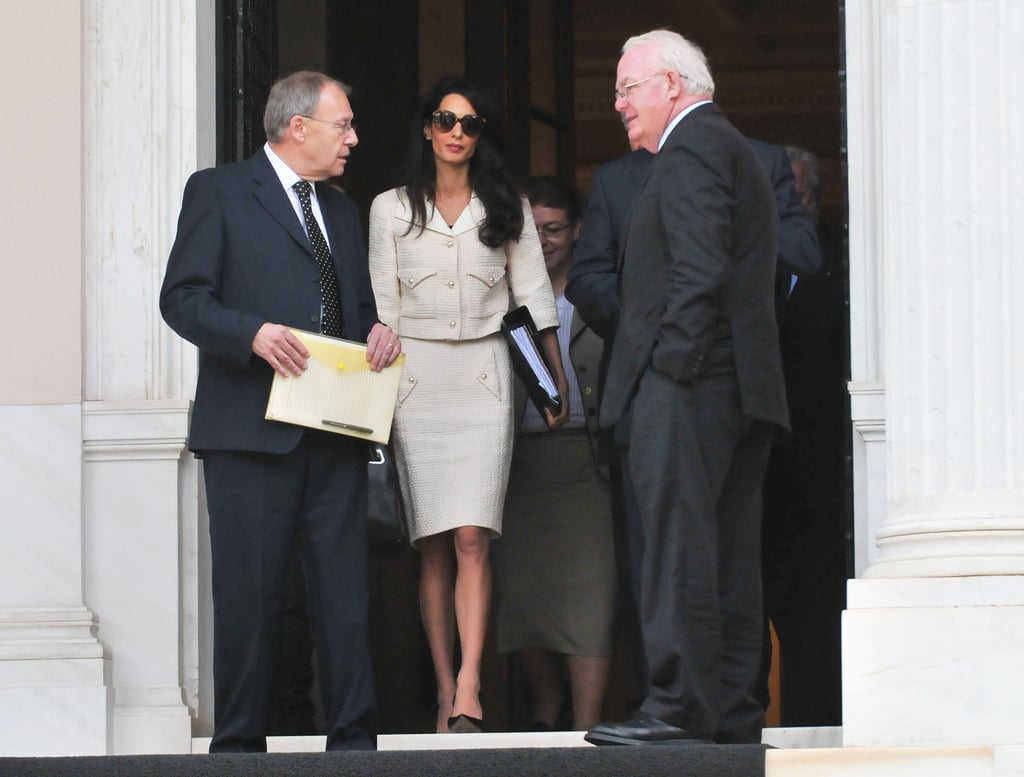 Amal's very chic Chanel cream suit was left unbuttoned on the runway, but Amal tidied it up with Prada sunglasses.