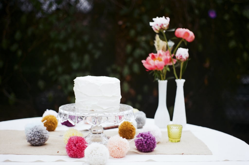 We can't get over how whimsical and stunning this simple cake is with the help of colorful pompoms.