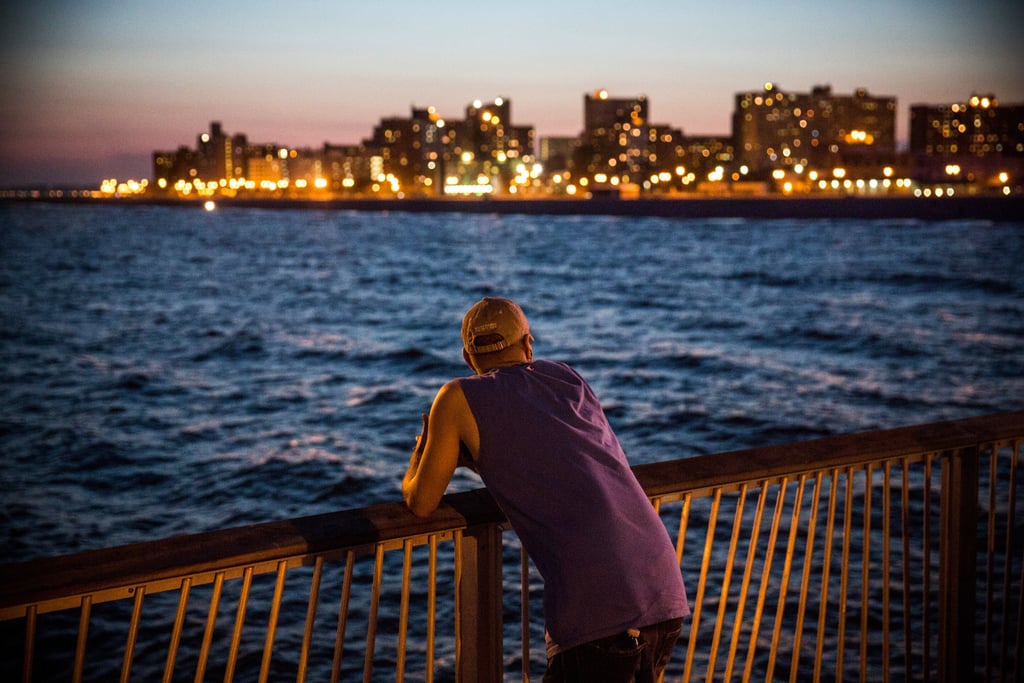 A man looked at the view of NYC from the Coney Island beach.