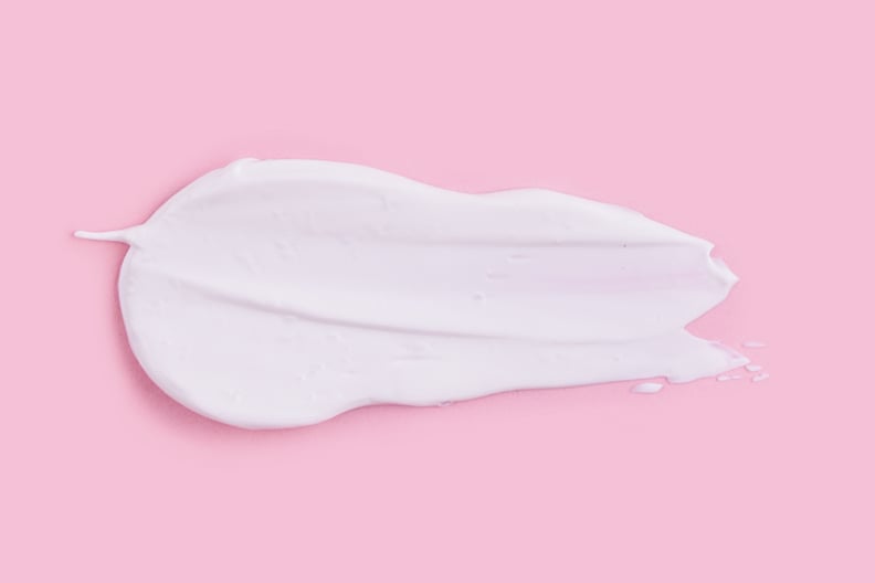 自然保湿涂片的粉色背景。奶油、面部或身体乳液。皮肤护理。