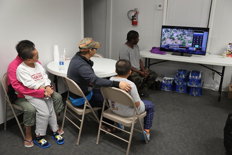 People rescued from their homes wait in an evacuation shelter.