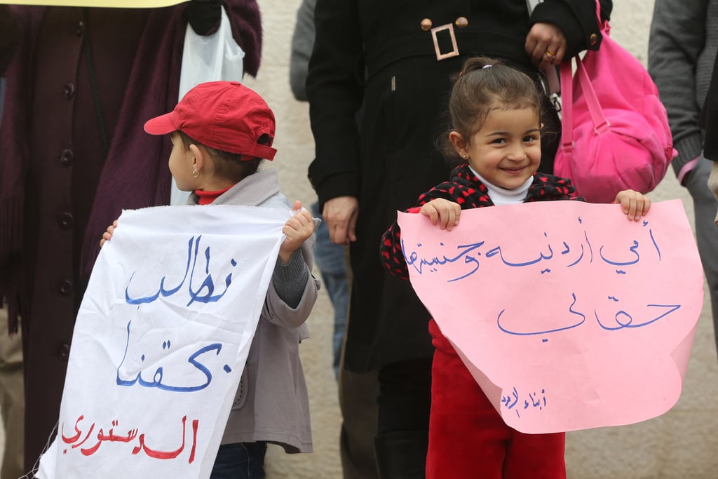 Jordanian women and kids held up signs protesting for the right of moms to pass on their nationality and citizenship to their children.