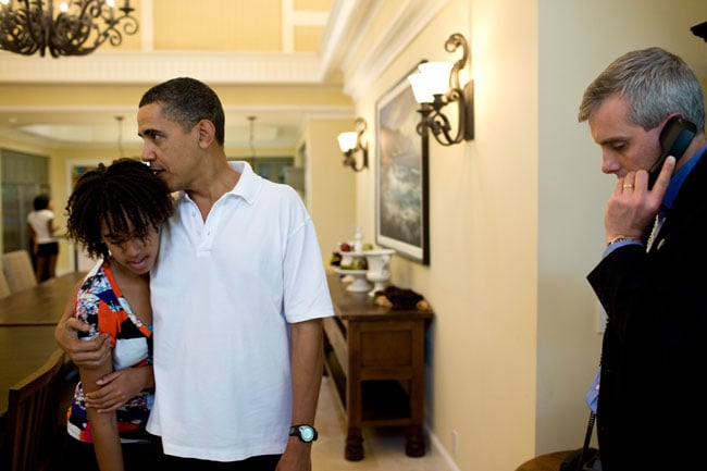 Obama hugging Malia while on vacation in Hawaii as he waits for a call about the attempted Christmas Day terrorist attack.