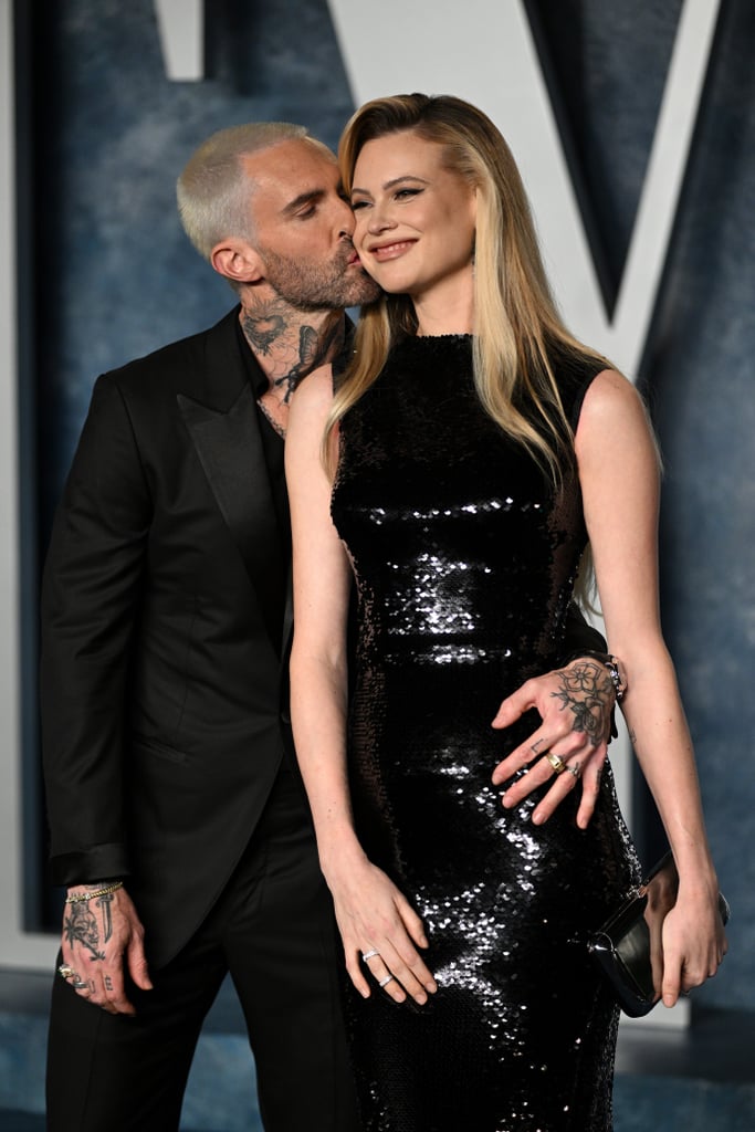 Adam Levine and Behati Prinsloo are returning to the spotlight six months after the Maroon 5 frontman's cheating scandal. The couple, who are now parents to three kids, made a loved-up appearance at the Vanity Fair Oscars party on March 12. With matching blond hair (Levine recently debuted a platinum buzz cut), the pair embraced and shared kisses for the cameras on the red carpet. The model stunned in a form-fitting sequin gown, while the singer coordinated in a suit with a casual V-neck tee underneath.
Less than two months ago, People confirmed the couple welcomed their third child together, though no other details were released at the time. The baby's birth came four months after cheating allegations against Levine came to light in September 2022 when multiple women accused the Maroon 5 musician of engaging in affairs while already married to Prinsloo. 
Levine addressed the accusations shortly after, admitting "poor judgment" and "flirtatious manner," but he denied any rumors of an affair. "In certain instances it became inappropriate; I have addressed that and taken proactive steps to remedy this with my family," he said. "My wife and my family is all I care about in this world. To be this naive and stupid enough to risk the only thing that truly matters to me was the greatest mistake I could ever make." 
Though the couple have been spotted out in public and shared on Instagram since then, they've mostly skipped public appearances and press until the Oscars afterparty. Prinsloo and Levine have been together for over a decade. They were first linked in June 2012 and later wed in July 2014. In addition to their newborn, they also share daughters Dusty Rose, 6, and Gio Grace, 5. 
Take a closer look at their red carpet return below. 

    Related:

            
            
                                    
                            

            Vanessa and Natalia Bryant Had a Mother-Daughter Night Out at the Vanity Fair Oscars Party