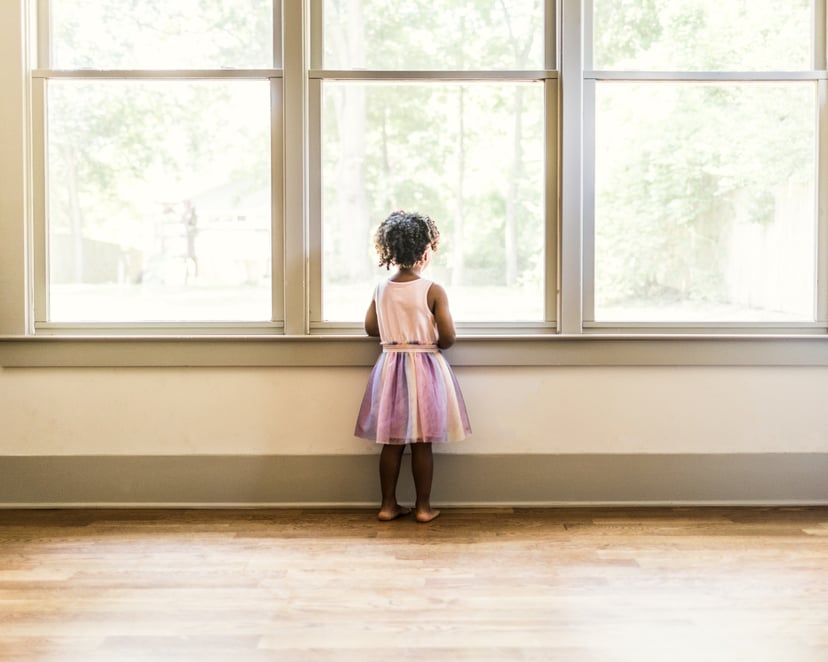 Portrait of preschool age girl looking out window