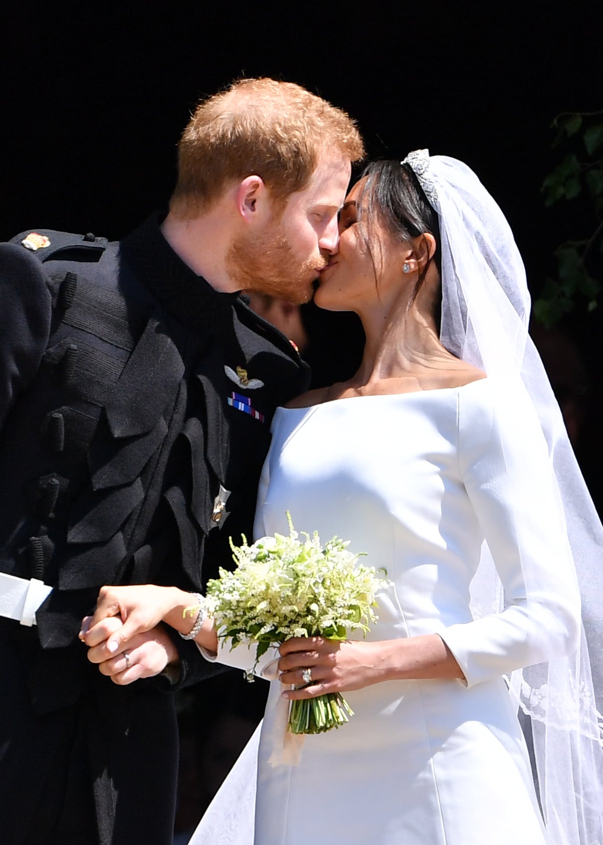 Britain's Prince Harry, Duke of Sussex kisses his wife Meghan, Duchess of Sussex as they leave from the West Door of St George's Chapel, Windsor Castle, in Windsor, on May 19, 2018 after their wedding ceremony. (Photo by Ben STANSALL / POOL / AFP)        (Photo credit should read BEN STANSALL/AFP via Getty Images)