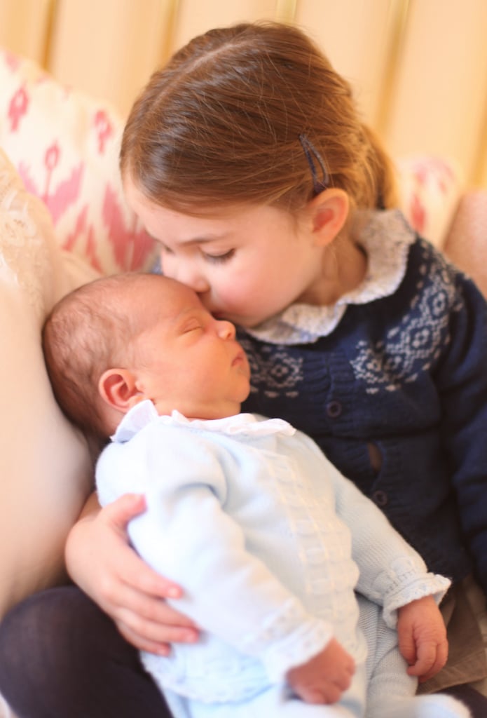 Prince Louis's first official portraits have arrived! Just a week after his exciting debut on April 23, new mom Kate Middleton shared more sweet photos of her baby boy taken on Princess Charlotte's third birthday at Kensington Palace. In one snap, big sister Charlotte plants a kiss on her brother's forehead, and, yes, our hearts are melting. In the other photo, Louis stares off into the distance with a serious look on his face, closely resembling his proud father, Prince William. 
Continuing with tradition, Kate was behind the lens to capture the adorable moment between the new royal and his sibling. The portraits mark the first time Kate and William's children have been seen together. William took George and Charlotte to meet Louis shortly after his birth at St. Mary's Hospital in London, but the toddlers were back at home before the royal couple posed for photos with their newborn outside the Lindo Wing.  

    Related:

            
            
                                    
                            

            Princess Charlotte Borrows From Prince George&apos;s Closet, Wears Hand-Me-Downs in Royal Portrait
        
    
The next major event for the royal family is Prince Harry and Meghan Markle's wedding, set for May 19. Although Louis won't be there, we can expect to see photos of George and his sister Charlotte stealing hearts as a pageboy and bridesmaid, respectively. Keep reading to see more cuteness from Louis's first official portraits, then check out our roundup of Charlotte's deliciously adorable portraits over the years.