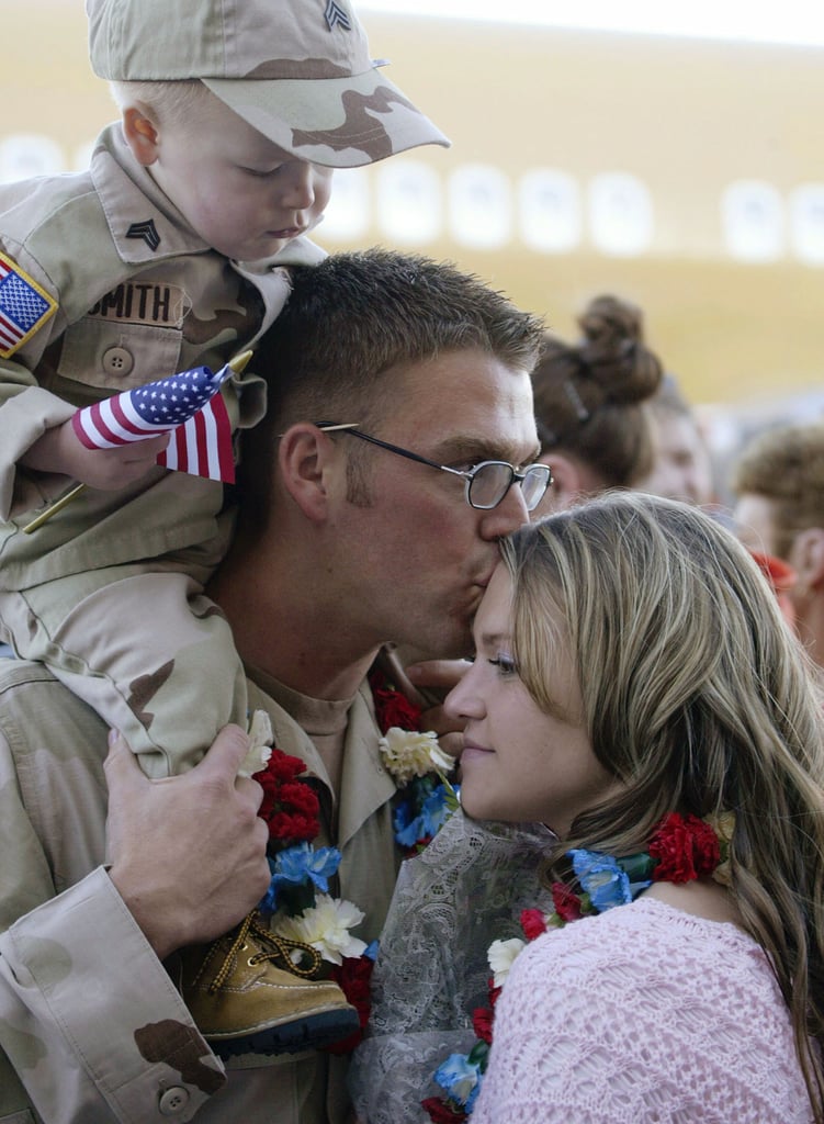 In 2004, Army Sgt. Cody Smith kisses his wife, Kelsie, while his nephew Brandon looks on in Salt Lake City.