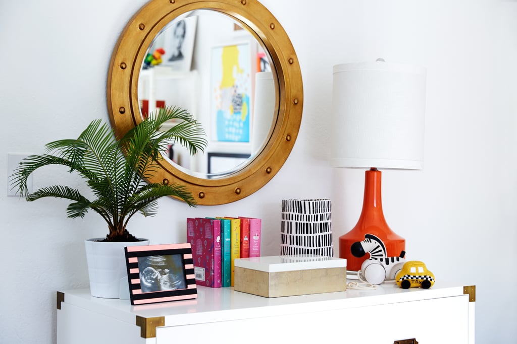 A white Campaign dresser with brass fixtures sets a chic tone and nods to tradition. At 42 inches wide, it easily accommodates a 30-inch changing tray on top, with plenty of room left for a punchy red lamp.