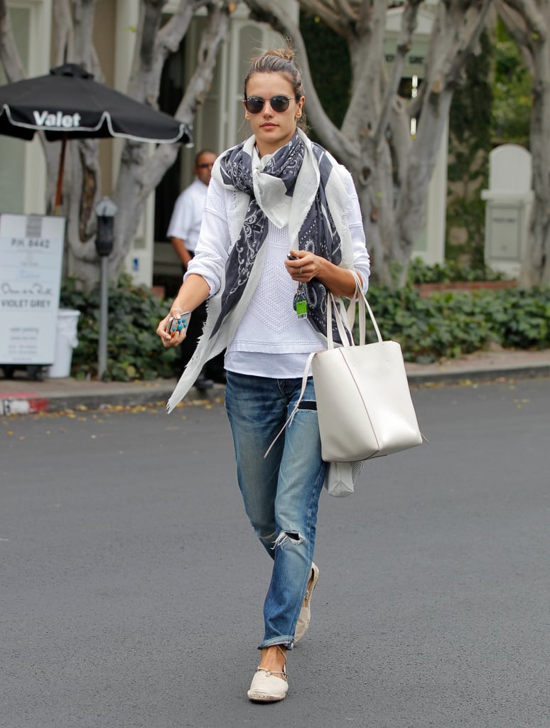 Alessandra Ambrosio mastered the laid-back LA vibe with boyfriend jeans, a white sweater, and a light printed scarf.