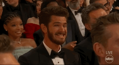 Andrew Garfield smiles awkwardly at the 2023 Oscars