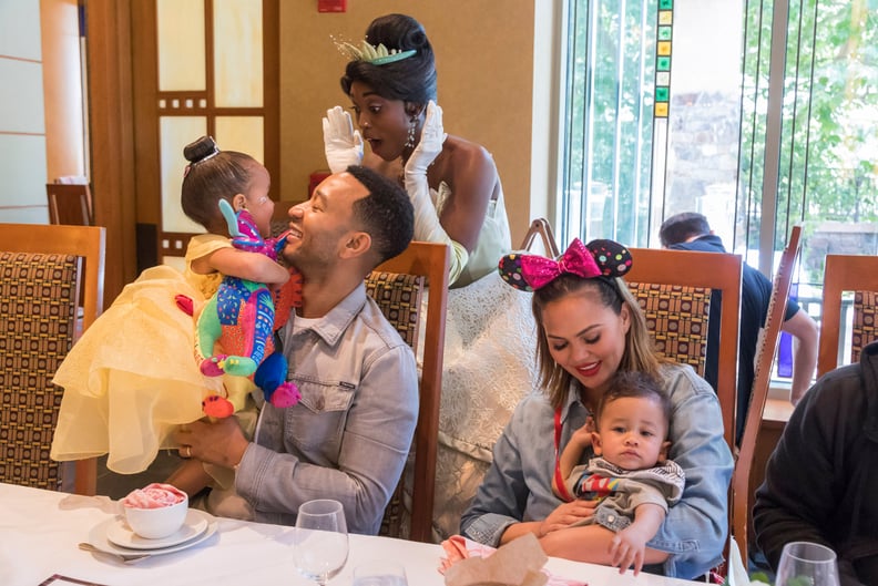 ANAHEIM, CALIFORNIA - APRIL 12: In this handout image, John Legend, Chrissy Teigen, their daughter Luna and son Miles share a moment with Princess Tiana during the Disney Princess Breakfast Adventures at Disney's Grand Californian Hotel on April 12, 2019 