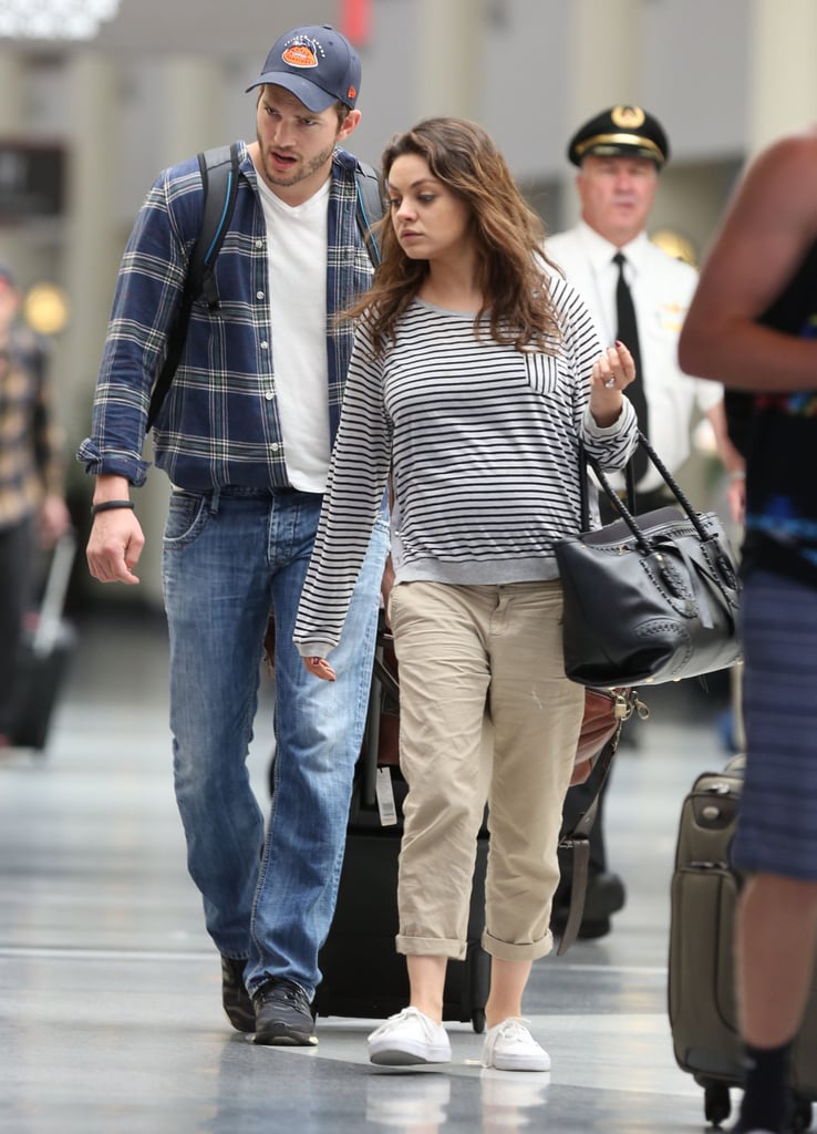 Mila Kunis Shows Baby Bump at Airport With Ashton Kutcher