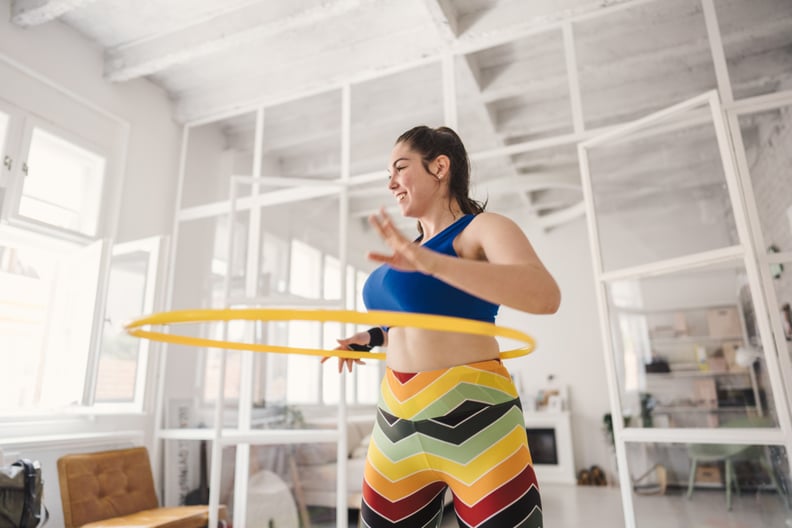 woman doing a weighted hula hoop workout
