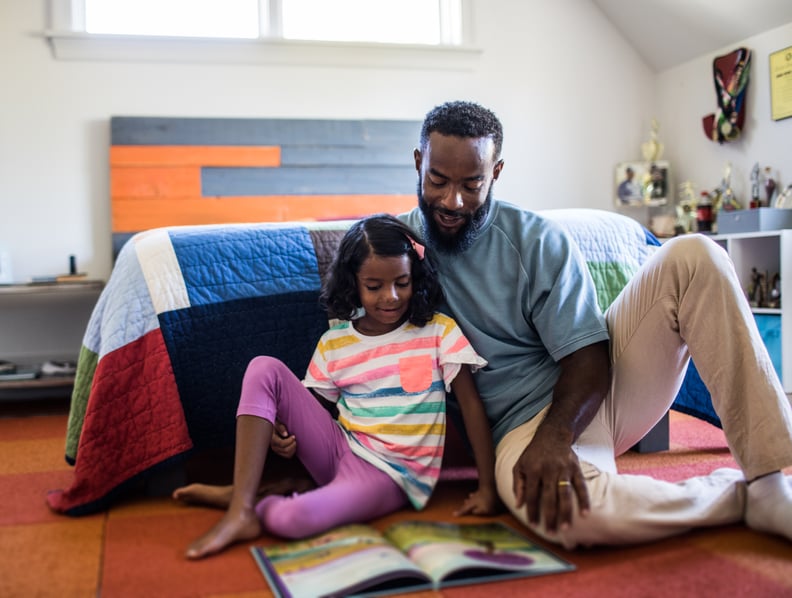 father and daughter reading in bedroom