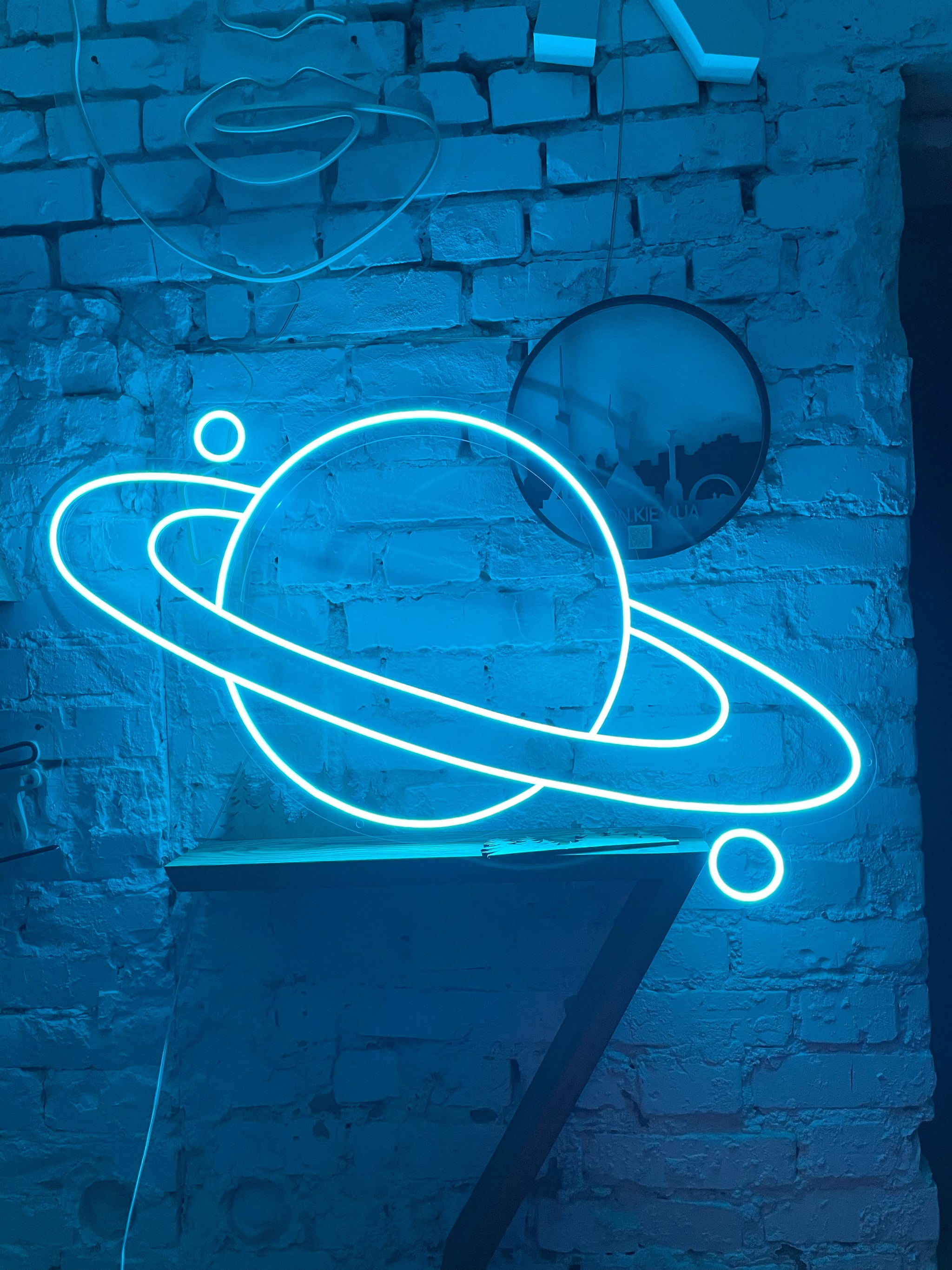 image of neon light in shape of saturn representing saturn in pisces