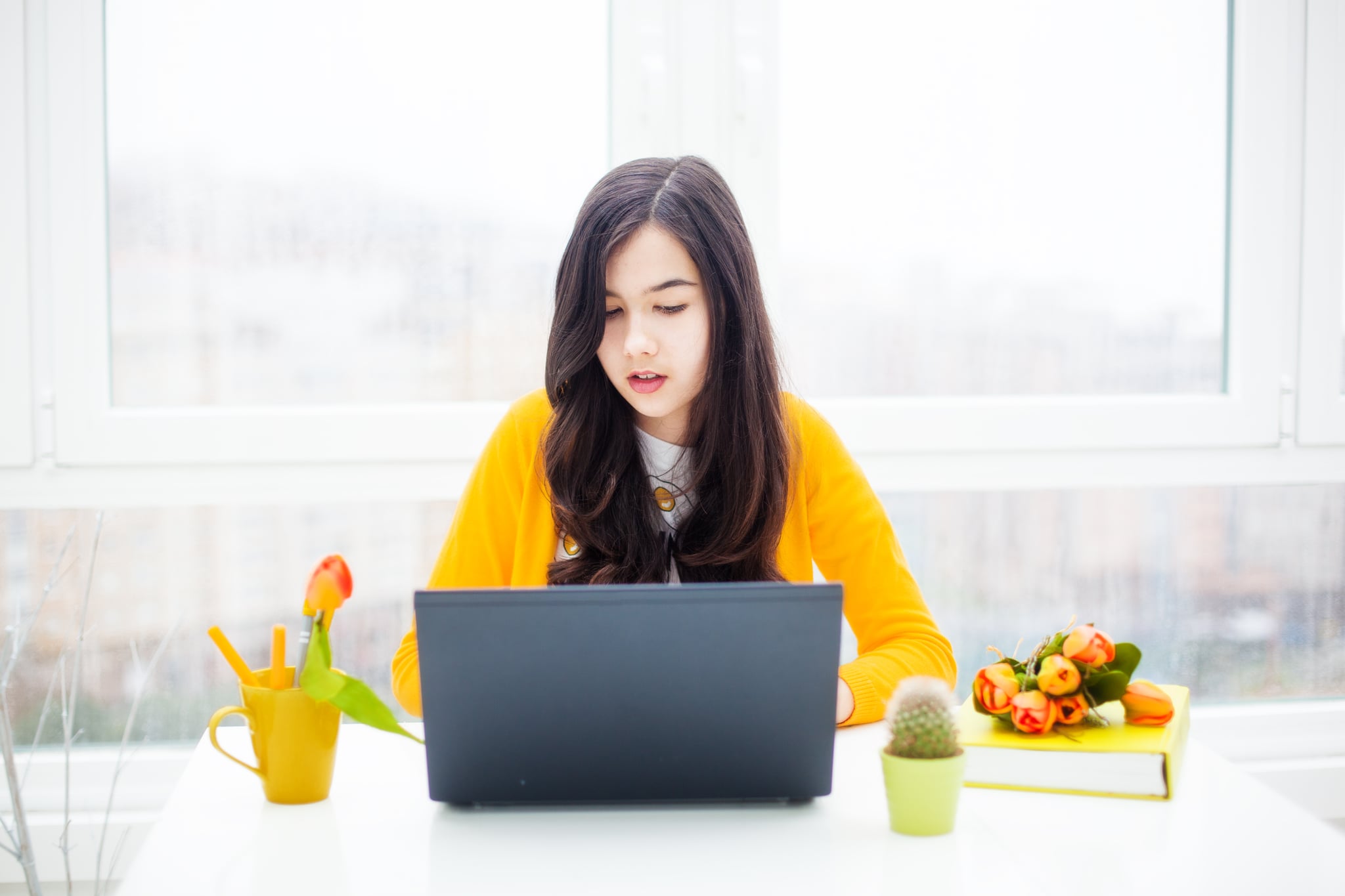 a teenager girl using laptop indoor