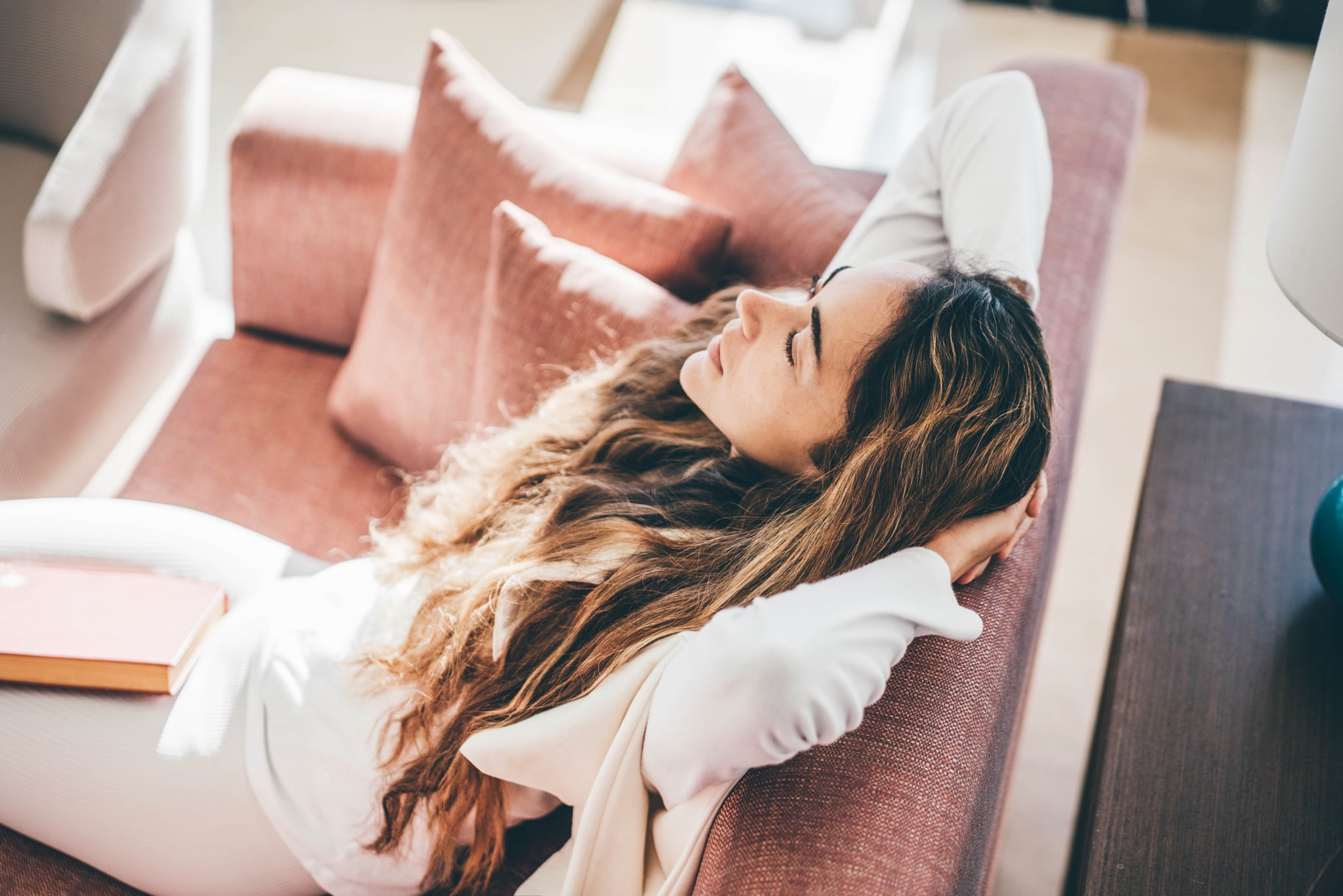 Woman relaxing on sofa in living room during the follicular phase.