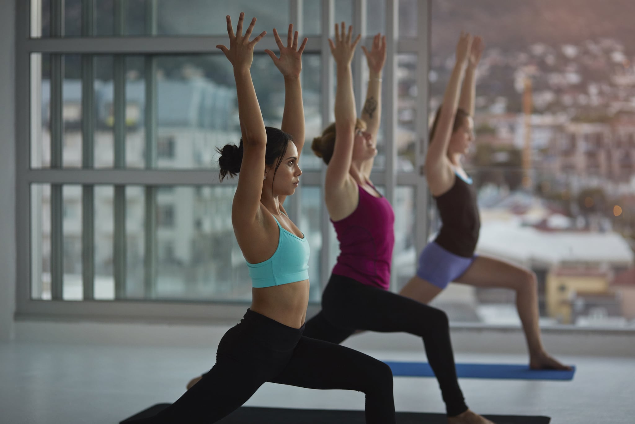 Yoga class practicing in huge rooftop studio at sunset