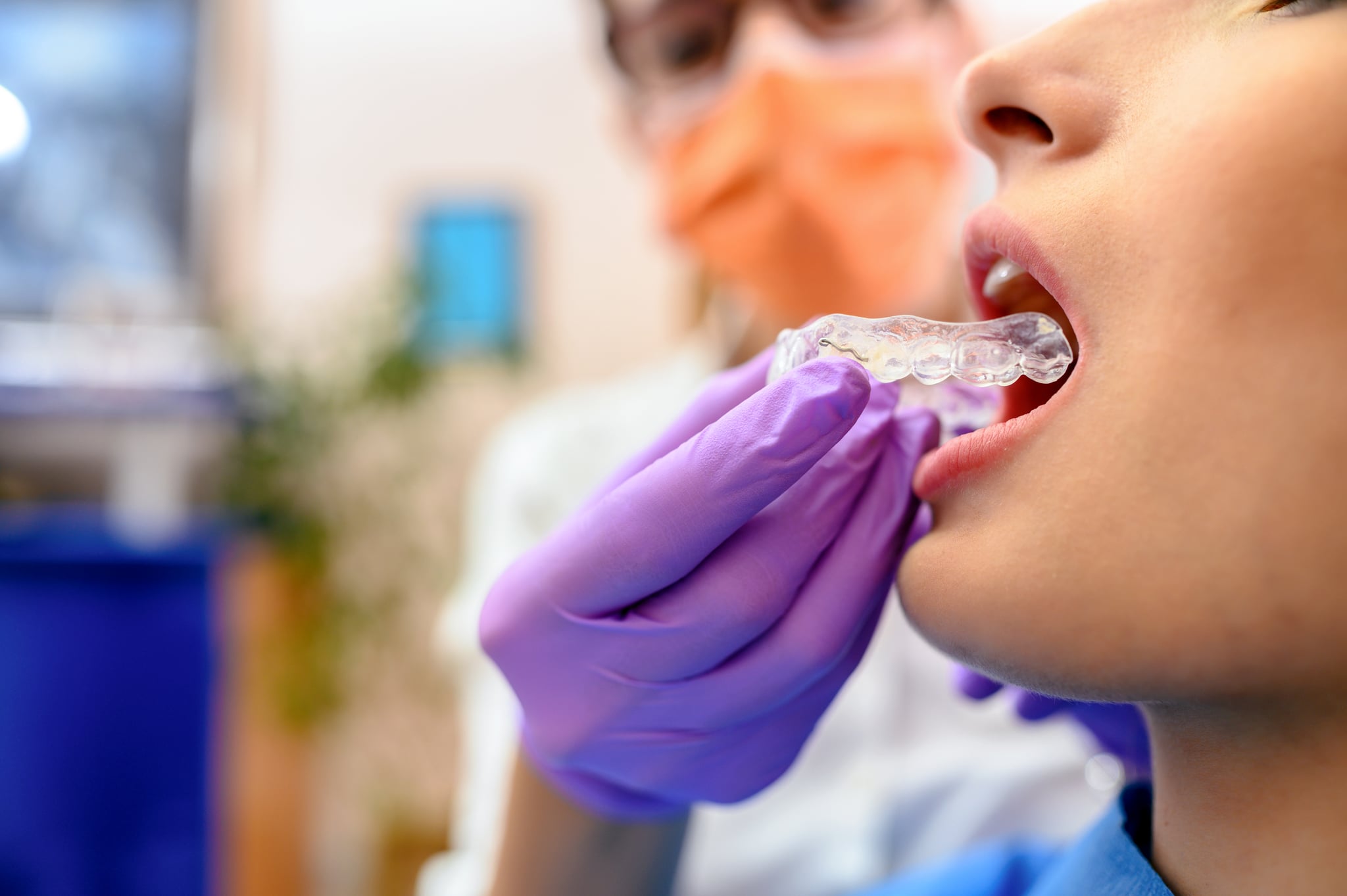 Dentist hand showing an implant to a patient in an office