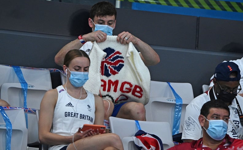 TOPSHOT - British diver Thomas Daley sits with his knitting as he watches divers in the preliminary round of the men's 3m springboard diving event during the Tokyo 2020 Olympic Games at the Tokyo Aquatics Centre in Tokyo on August 2, 2021. (Photo by Oli S