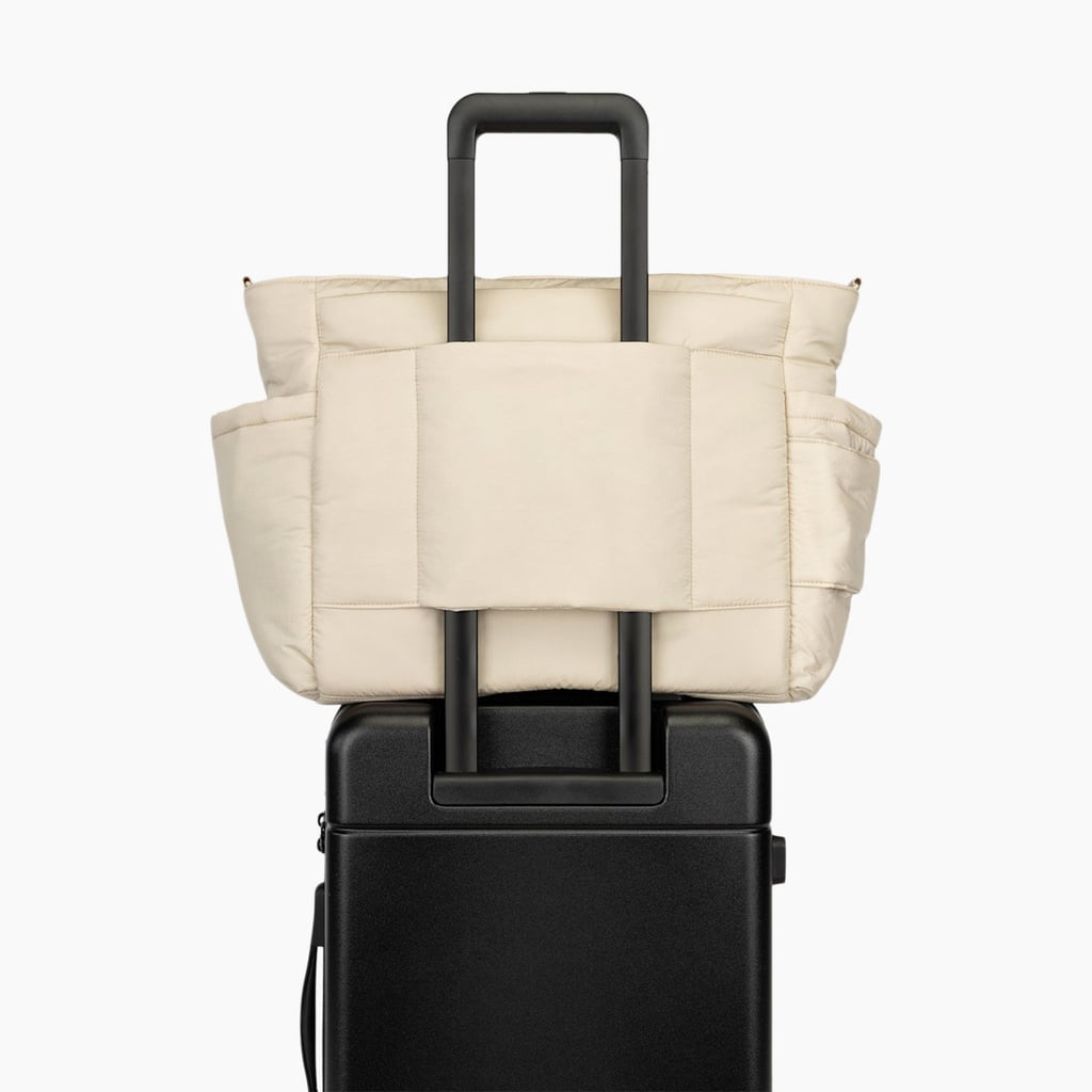 Calpak Diaper Tote Bag With Laptop Sleeve ($137, originally $195)
Calpak is a beloved travel brand, so it's no surprise they've created a bestselling diaper tote that works for plane rides. Available in oatmeal (pictured here), black, and hazelnut, the design is crafted from recycled nylon and recycled polyester and even has a 16-inch laptop sleeve, plus a luggage trolley sleeve with a back pocket for maximum storage. There are also two insulated bottle pockets and a dedicated baby wipe compartment.
Pros: Soft fabric and easy to clean.
Cons: The padded laptop sleeve doesn't fit all laptops.
Material: Recycled nylon and polyester.
Dimensions: 13.5" height x 20.75" width x 7" depth
Colorways: 3
Who it's best for: Moms.
Extras: Has all the organization compartments for various needs, including bottle insulation.
What Reviewers Say: "Becoming a mom of 3 soon (newborn, 2 year, 4 year old) and wanted just one lightweight big bag to carry everything for 3 kids. Took the bag out on a trial run and I can say it's what I was looking for. Pockets for everything, lightweight (this was the most important to me), easily wipeable, and not hideous to look at. After I grow out of the diaper stage, I plan on continuing to use it like a weekender bag for trips."