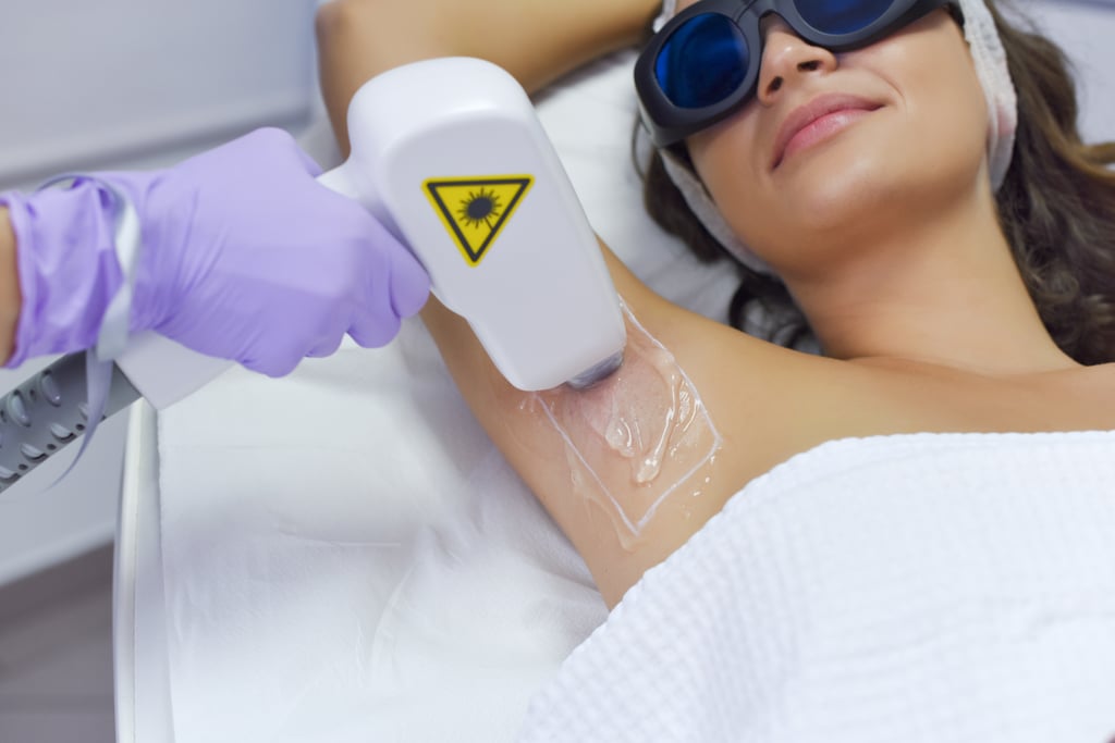 How Does Laser Hair Removal Work? 
"Laser hair removal works by emitting a monochromatic beam of light that bypasses the epidermis and disables the reproductive cycle of the hair within the follicle," said Christian Karavolas, laser hair removal expert and founder of Romeo & Juliette Laser Hair Removal. The laser does this by picking up the pigment in the hair and targeting that area. This is what makes lasers effective at providing long-term results.
The treatment areas available differ by spa, but you can pretty much get laser hair removal anywhere you have hair and typically shave. This includes legs, underarms, arms, bikini line, back, face, lower stomach, and even full Brazilian. 
Who Is the Best Candidate For Laser Hair Removal?
Gone are the days when laser hair removal was only safe for people with lighter skin tones. "In this day and age, lasers are so advanced that people of all skin colours and hair types are candidates," said Karavolas. While it used to be an issue because the lasers would target the pigment in the skin as well as the pigment in the hair, new advancements in technology have fixed that. 
"Alexandrite Lasers have a short wavelength that are more potent on the epidermis and therefore are more suited for lighter skin and lighter hair," he said. "ND Yag lasers are best suited for dark skin and coarse hair, as they bypass the epidermis, therefore giving a safe treatment without damageing the skin." Those with darker skin should just check with the location they plan on visited to ensure they have the proper equipment. 
When Is the Best Time to Start Hair Removal Treatments?
Here's the tricky part. Even though hair removal is top of mind in the spring as you book your summer holidays, that's not the best time to get it. "The best time to start laser hair removal is fall to winter," said Karavolas. "If you expose your skin to the sun without sunscreen or get very tan, we recommend you wait for the cooler months." 
That doesn't mean it's impossible to get it in the summer, but you will need to be more careful to ensure the skin doesn't get any colour by avoiding the sun and wearing a high SPF. You also can't have any self-tanner products on at the time of your appointment which are commonly worn in the summer. 
What Treatments and Products Should You Avoid While Getting a Laser Treatment?
We already covered that tanning products should be avoided during a laser treatment, but that's not all. "Any topical retinoids or harsh antibiotics that may cause photo-sensitivity should be avoided," said Karavolas. This is important to note if you plan on getting an area on your face treated and use skin-care products with retinol in them.