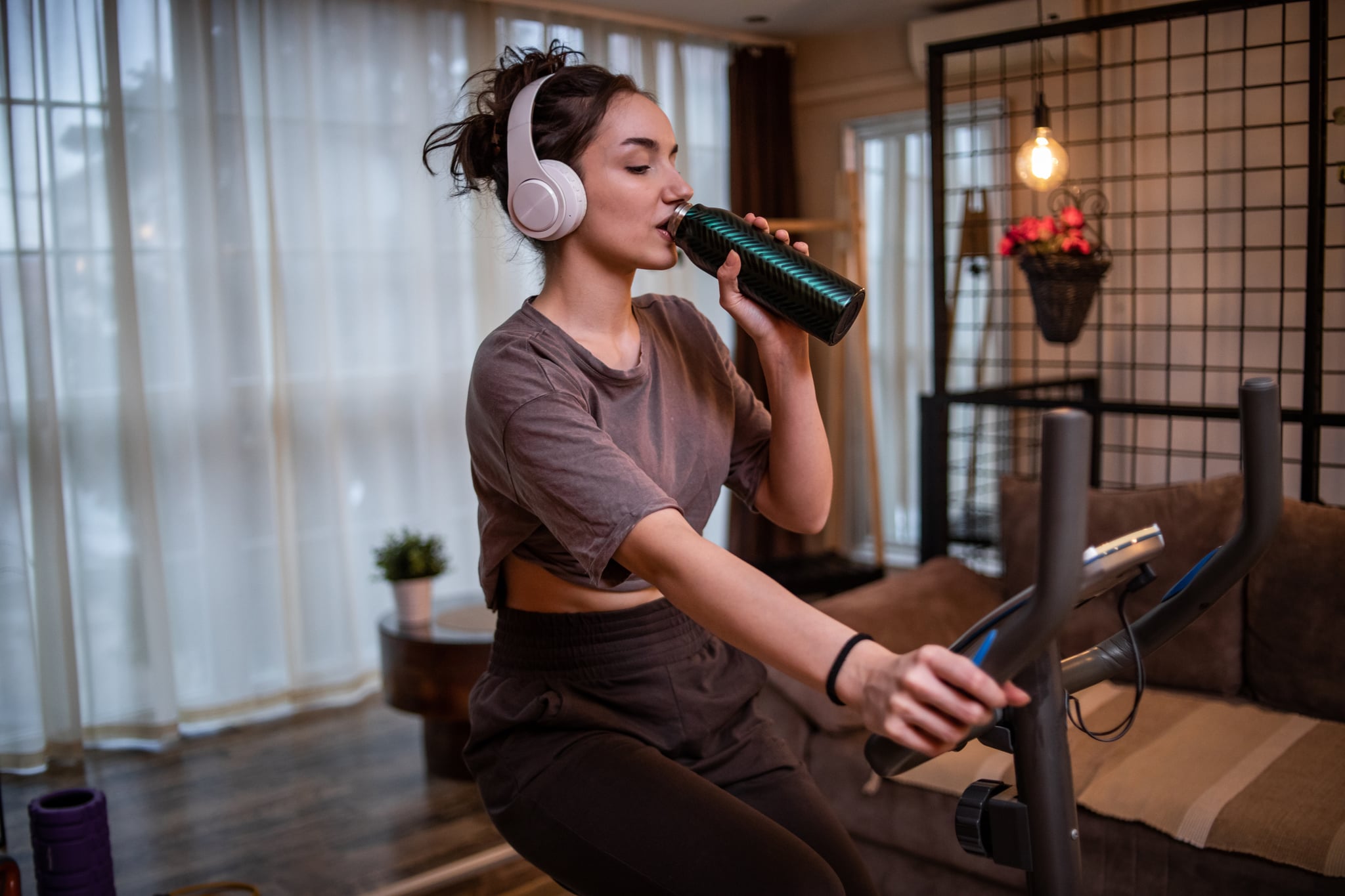 young woman doing cosy cardio at home on an exercise bike