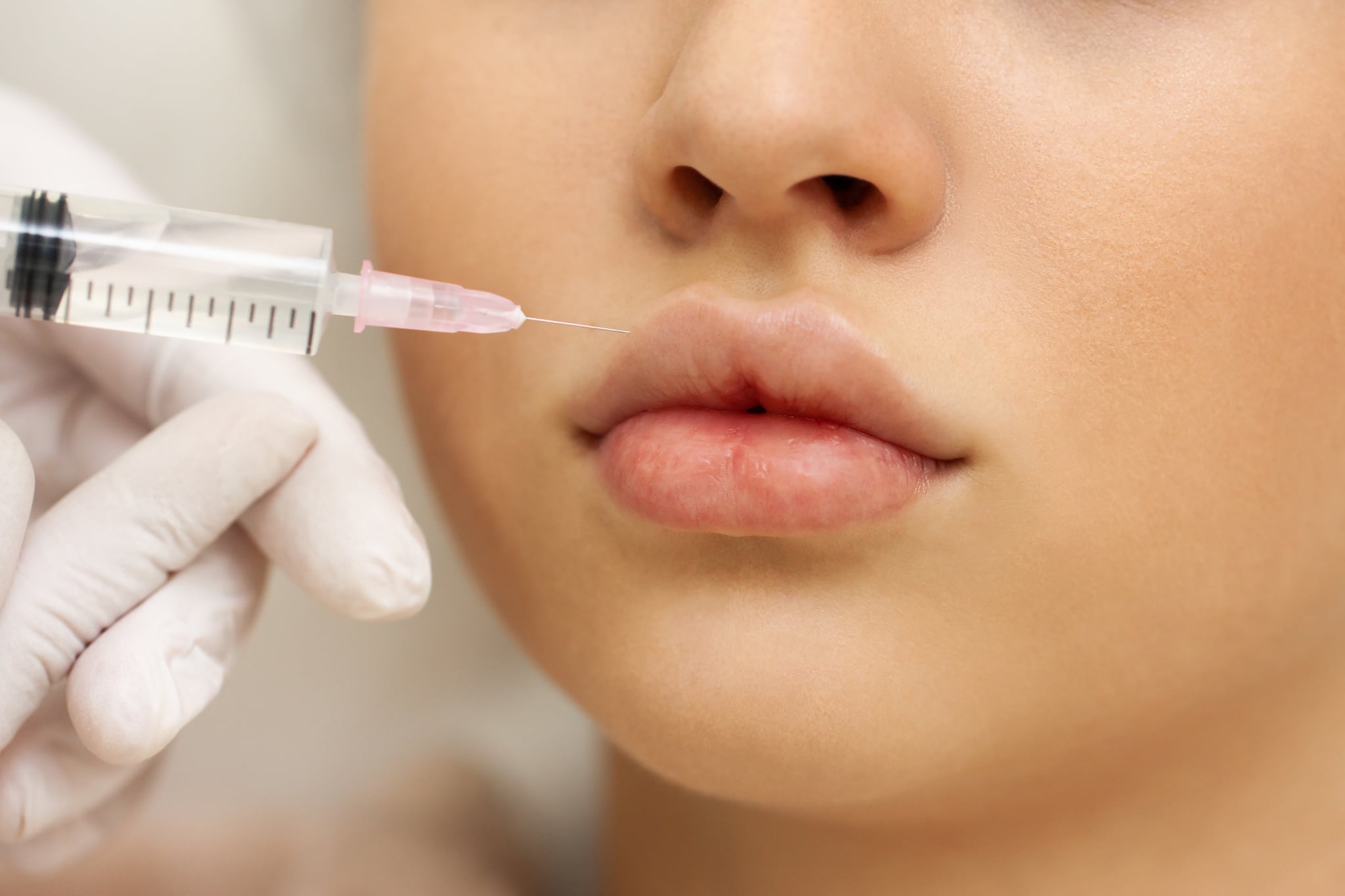 Woman at the beautician. The concept of lip augmentation, injection cosmetology, anti-ageing procedures.