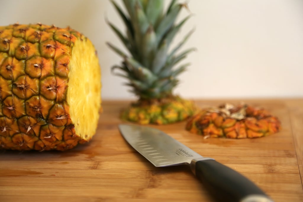 Rotate the pineapple and cut off the bottom. This way, the pineapple can stand up on either end. Rotate the pineapple and cut off the bottom. This way, the pineapple can stand up on either end.