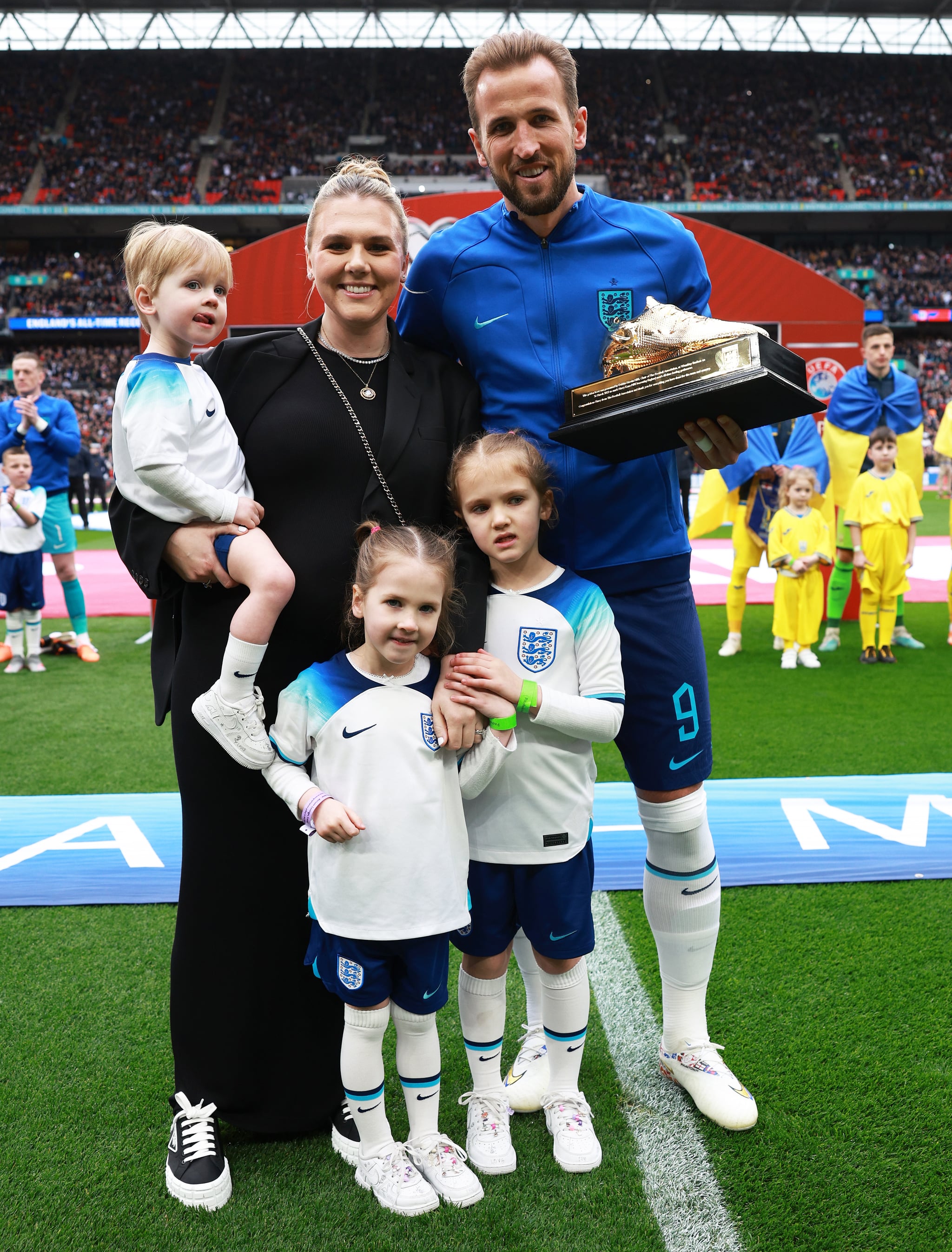 LONDON, ENGLAND - MARCH 26: Harry Kane of England poses with their Golden Boot trophy alongside their Wife, Katie Goodland and Children, Ivy Jane Kane, Vivienne Jane Kane and Louis Harry Kane prior to the UEFA EURO 2024 qualifying round group C match between England and Ukraine at Wembley Stadium on March 26, 2023 in London, England. (Photo by Eddie Keogh - The FA/The FA via Getty Images)