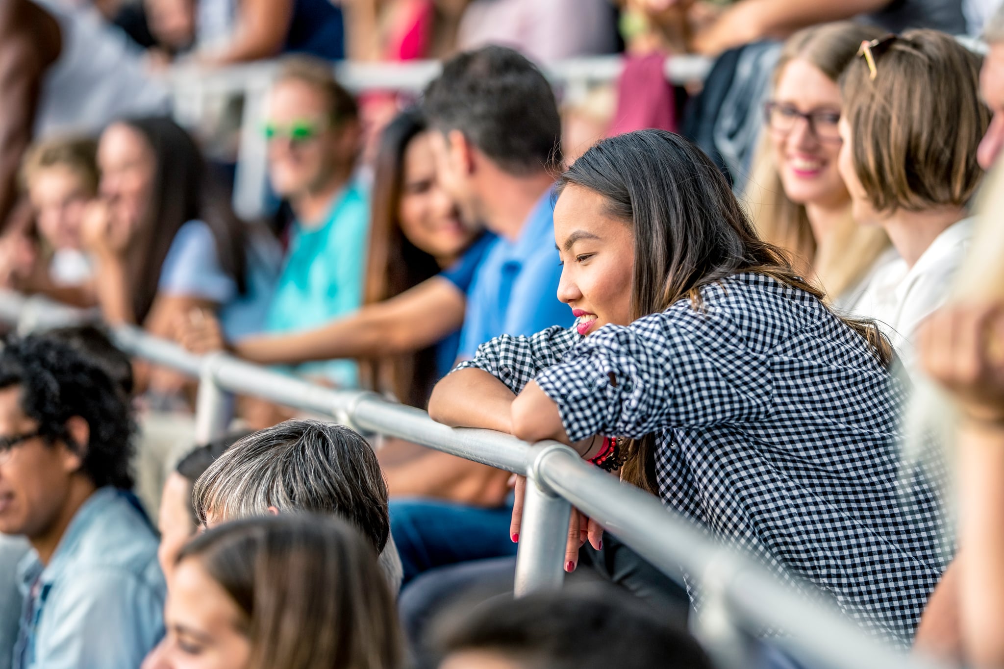 young woman watching tennis in the stands