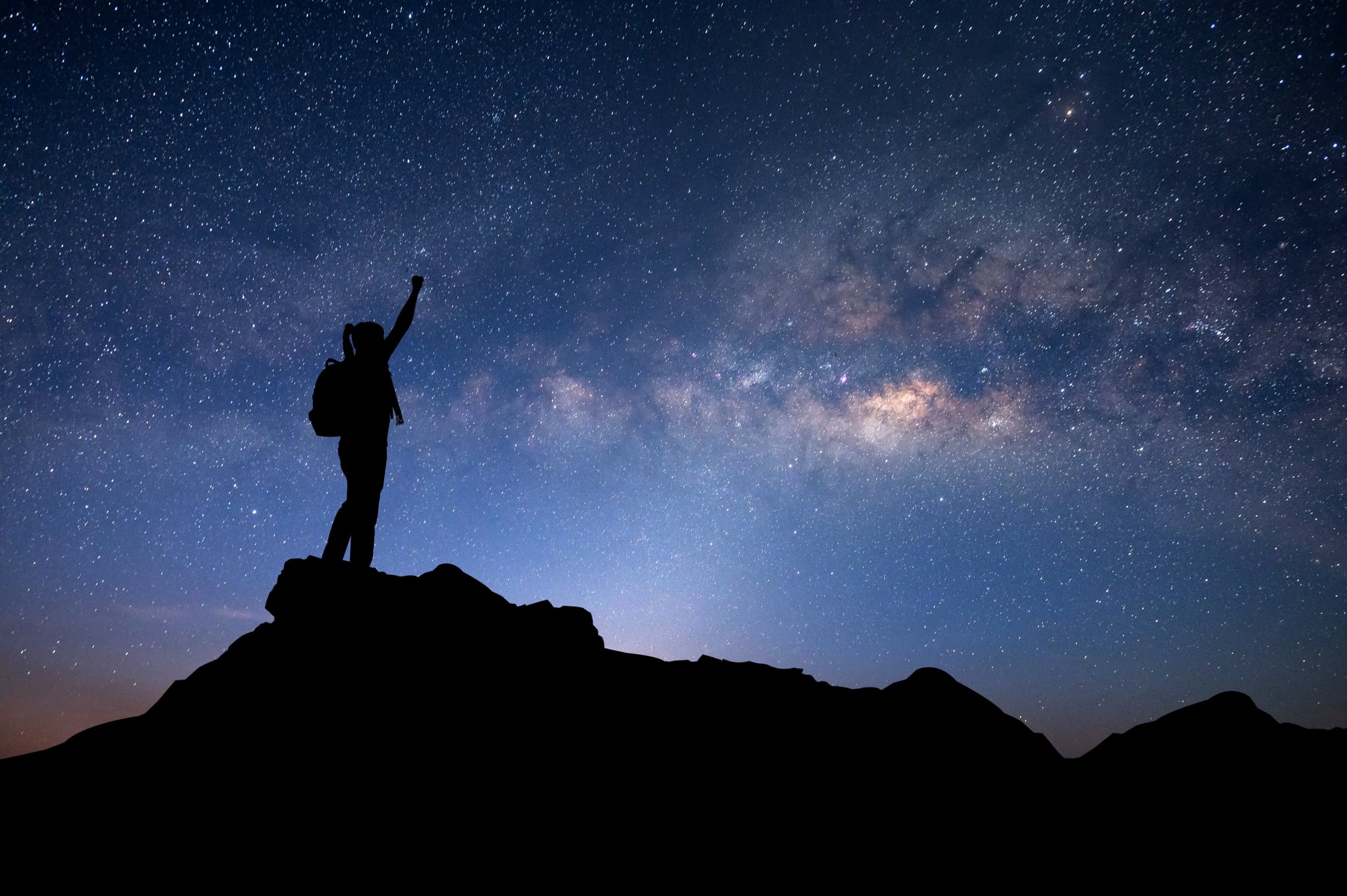 Many stars , Milky Way and Silhouette of man standing a lone on top of mountain and show two hands isolated on white background.Concept to create energy and positive thinking.
