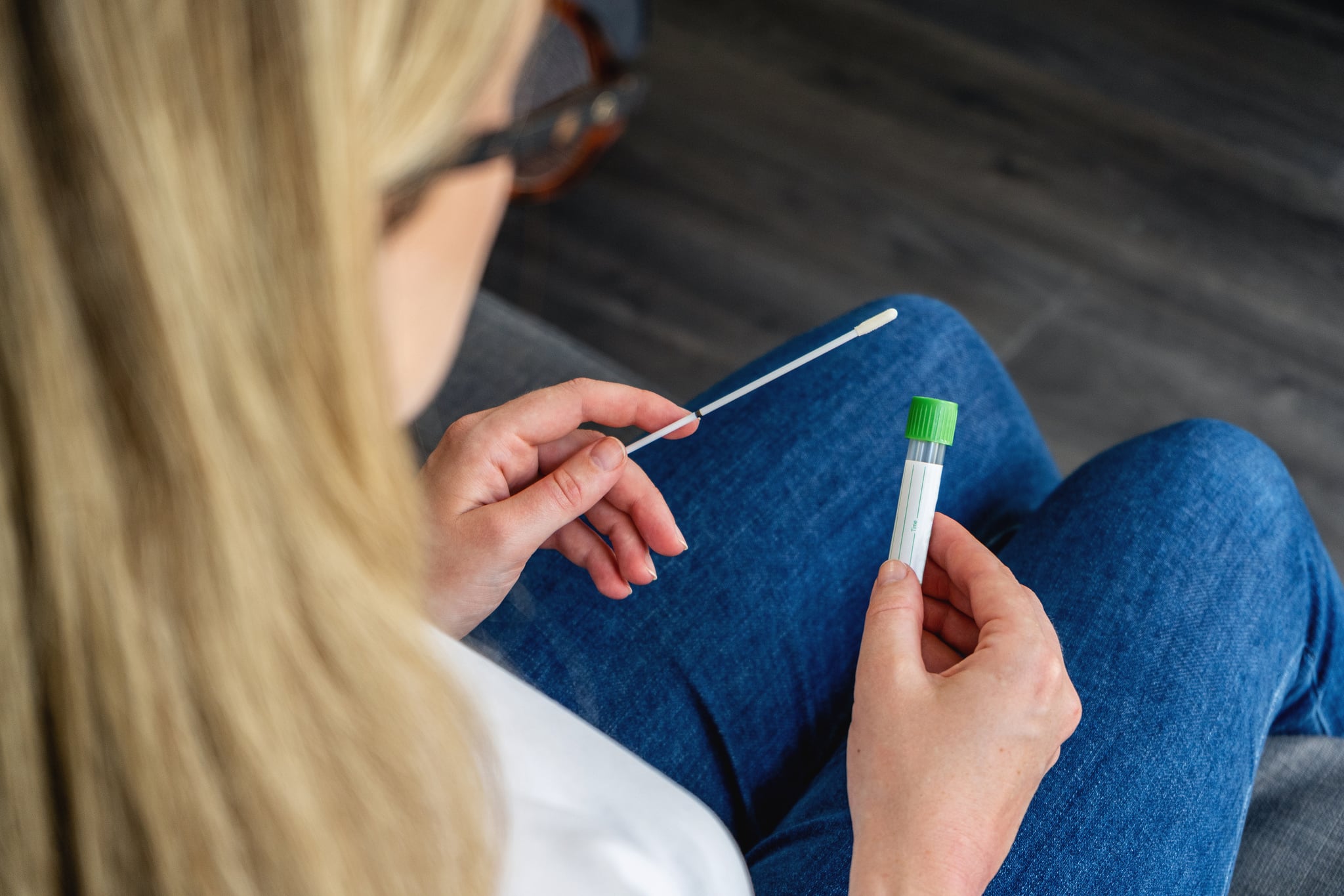 Young woman  holds a swab and medical tube for the coronavirus / covid19 home test