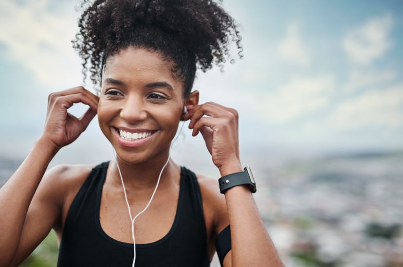 Shot of a sporty young woman listening to music while exercising outdoors