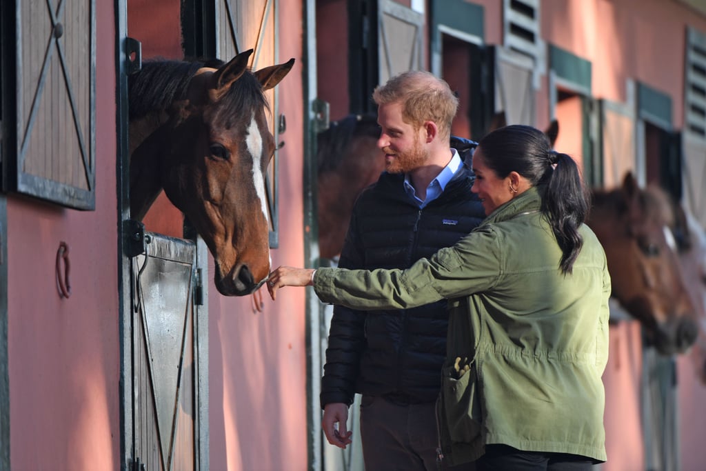 Prince Harry and Meghan Markle's Moroccan tour is in full swing, and their first stop on Monday morning was the Royal Equestrian Club in Rabat, where they learned how the equine therapy helps young people with mental health challenges, as well as disabled children. During the visit, the couple witnessed how the equine exercises helped the children, met with those involved in the club, and got to meet some of the beautiful horses. Meghan and Harry looked delighted as they got up close with the gorgeous animals.
Later on today, Meghan and Harry will cook pancakes with a group of children with a recipe from Meghan's Together cookbook. Ahead, get a closer look at Meghan and Harry's third day of activities in Morocco.