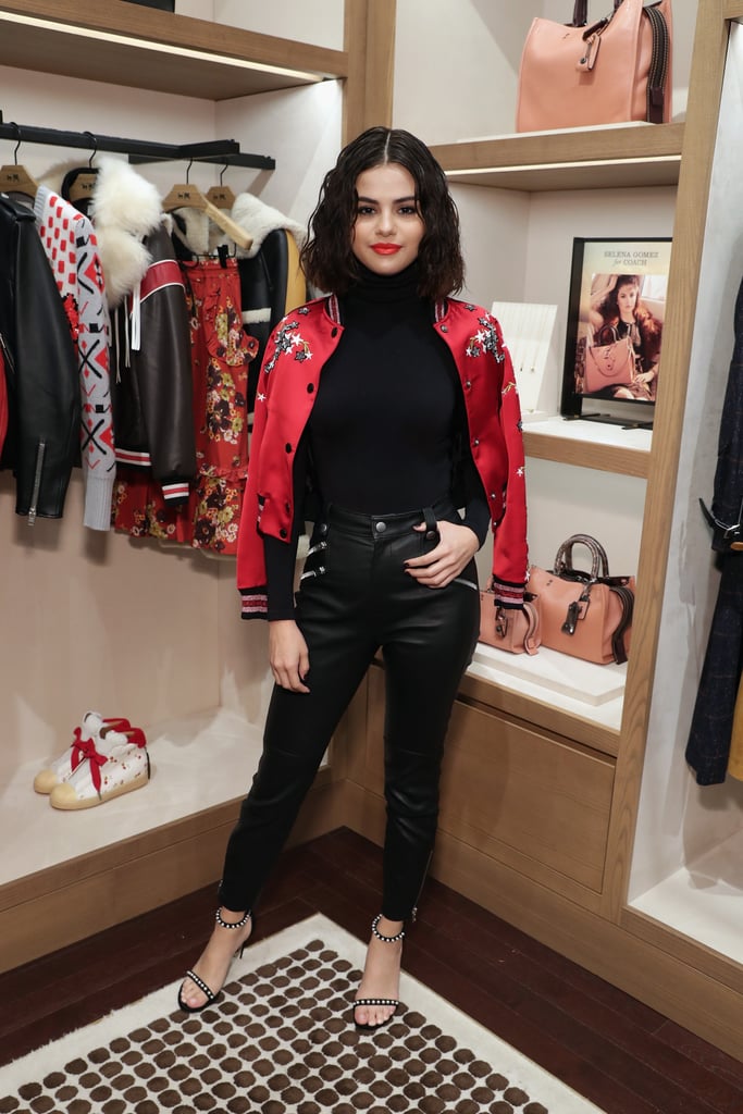 While in NYC, the star made time to stop by the Coach store for an appearance promoting her collab with the label. Selena wore a monogrammed bomber jacket with her all-black outfit.