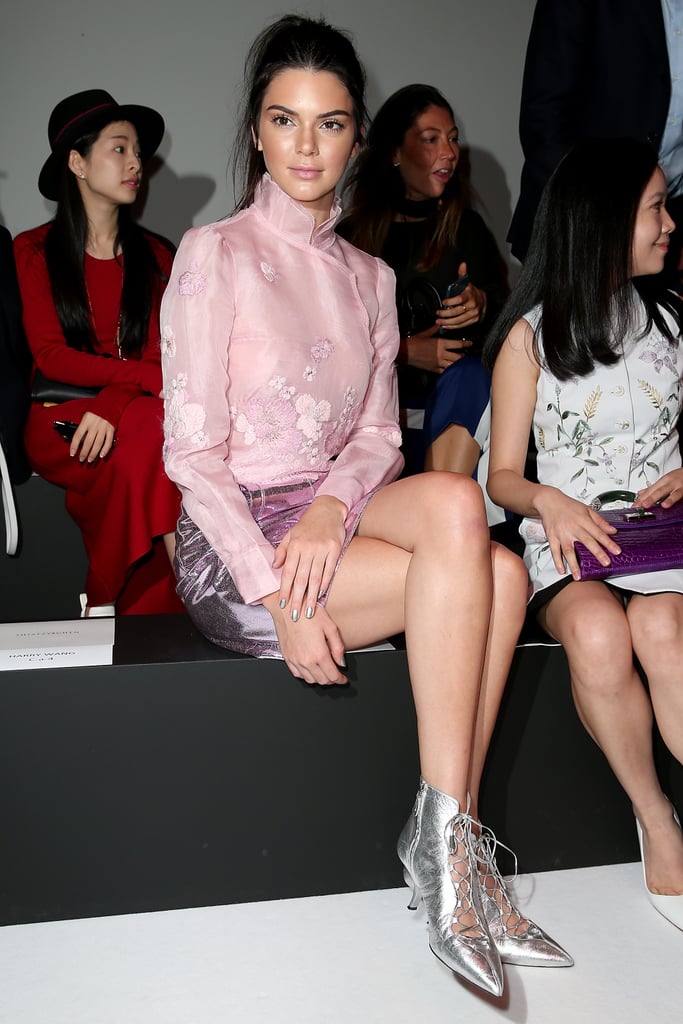 Kendall sat front row at the Shiatzy Chen show wearing a high-neck pink top and coordinated metallic skirt along with silver lace-up booties.