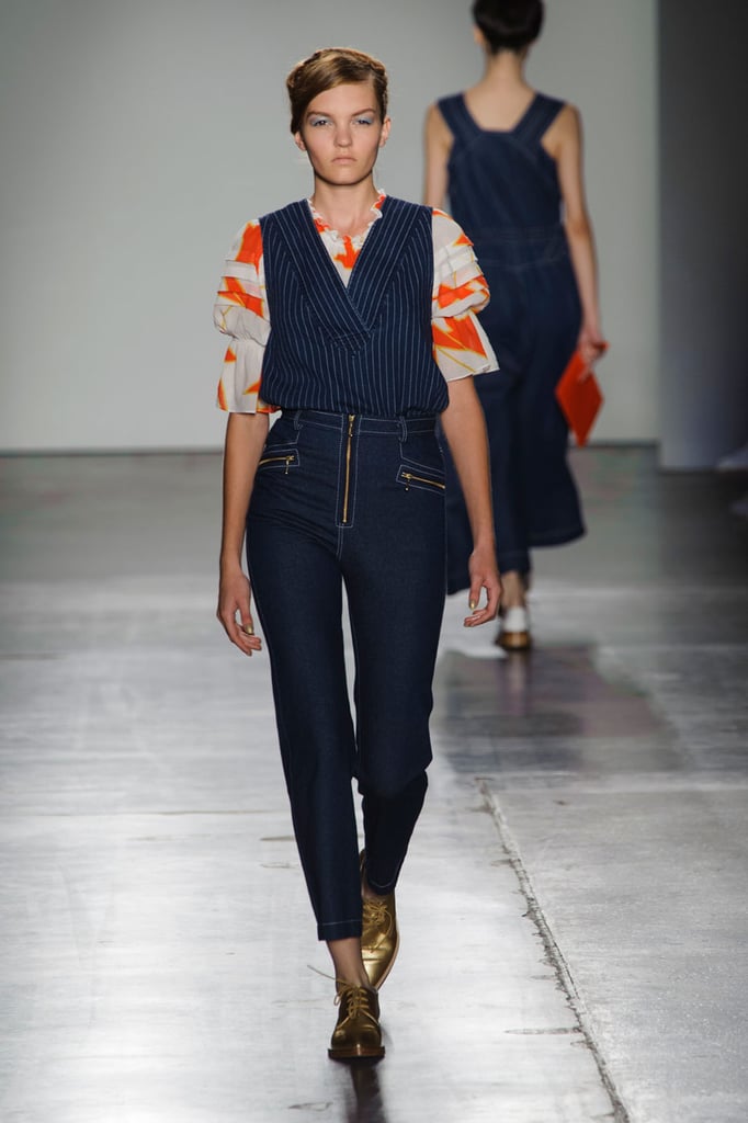 A printed blouse, vest, and high-waisted trousers.