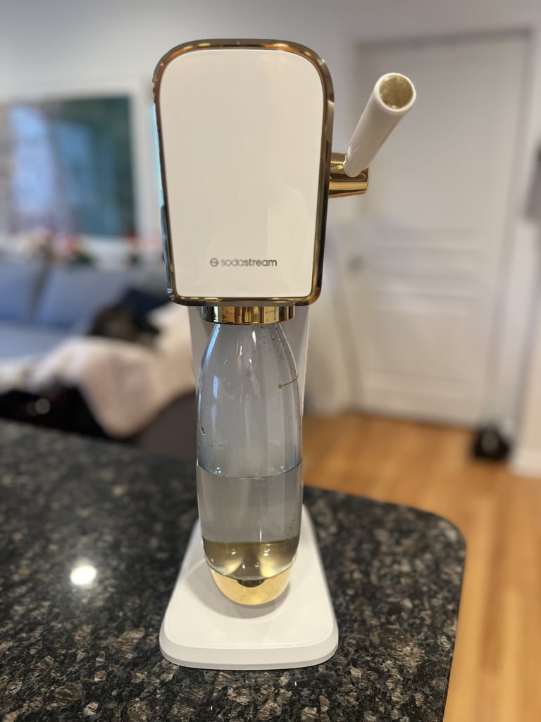 SodaStream Art Sparkling Water Maker ($90, originally $130)
The beauty of a sparkling water maker is that you can transform flat water with just the push of a lever — and because the device simply uses Co2 to function, you don't even have to plug it in. This white/gold shade is limited edition, and it comes with a Co2 cylinder and BPA-free, dishwasher-safe, reusable carbonating bottle that you simply snap into place to whip up your beverage. SodaStream has also introduced cocktail mixers ($19) and offers plenty of Bubly flavor additions ($22) if you prefer to make your drink with a twist.
Editor Quote: "My partner and I tend to crave an ice cold Diet Coke from time to time, and the SodaStream gives us a healthier option that is still every bit as satisfying. It tastes great and is incredibly easy to clean and use. The gold accents also add a chic touch to our kitchen countertop." — Sarah Wasilak, shopping director