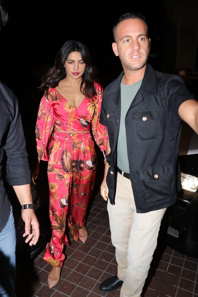 At the JW Marriott, Priyanka wore a red crop top and high-waisted pants covered with a tropical print.