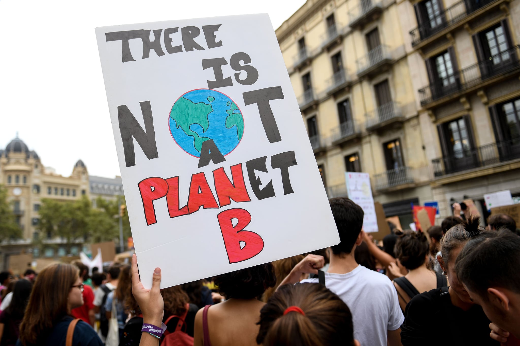 A demonstrator holds a placard reading 